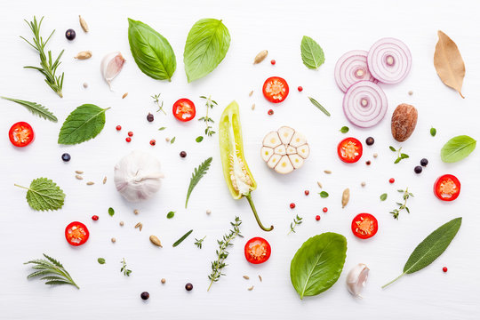 Various fresh herbs for cooking ingrediens peppermint , sweet basil ,rosemary,oregano, sage ,chilli bay leaves and lemon thyme on white wooden background with flat lay .