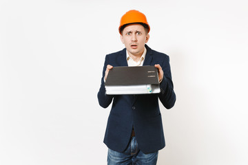 Concerned dissatisfied businessman in dark suit, protective construction helmet holding black folder for papers document isolated on white background. Male worker for advertisement. Business concept.