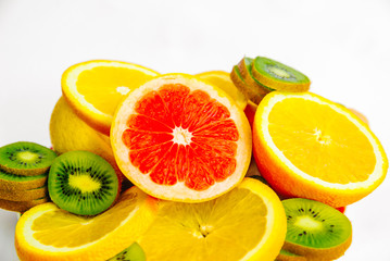 Exotic fruits on a white background. Grapefruit, orange, lemon, lime and kiwi in a cut