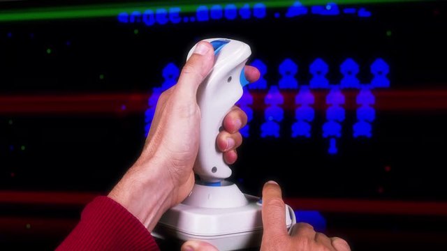 a hand using a retro computer arcade game joystick