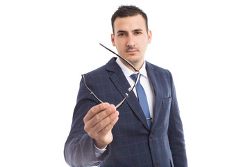 Optics concept with young businessman holding glasses .