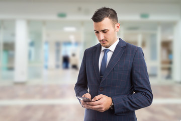 Young bussinesman or manager texting on smartphone.