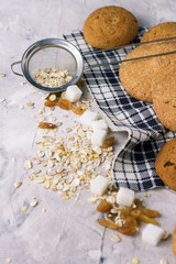 Oatmeal cookies on linen napkin and stone background. Oatmeal, raisins, sugar cubes. Scene from breakfast