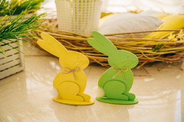 Easter rabbits made of wood are green and yellow. Spring or summer children's background. Decorative toy rabbits