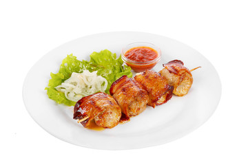 Shish kebab, beef, lamb, pork, chicken in bacon grilled meat, barbecue, without garnish on a plate, isolated on white background. Marinated onion, ketchup, tomato red sauce. Side view For the menu