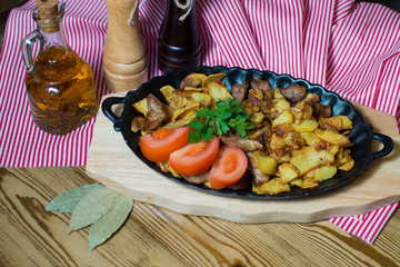 potatoes fried meat in a frying pan on a tree
