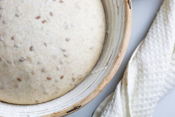 Dough with natural leaven with flax seeds in a rattan basket. The concept of a healthy diet. The style of life.