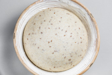 Dough with natural leaven with flax seeds in a rattan basket. The concept of a healthy diet. The style of life.