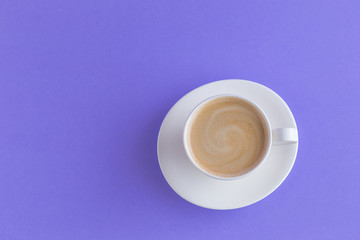 white a cup of coffee on violet background toned.