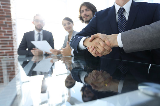 handshake business partners at the meeting.