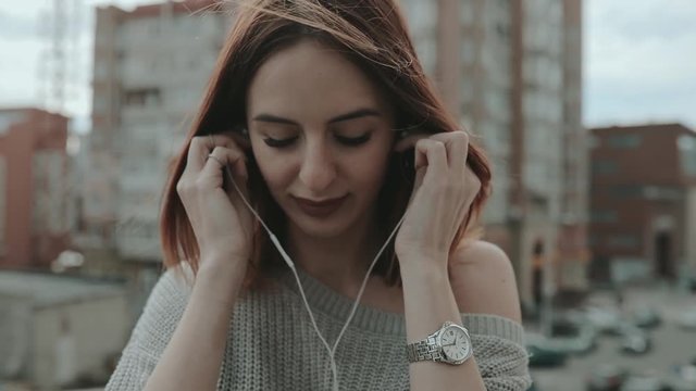 Woman listening to music in city with earphones