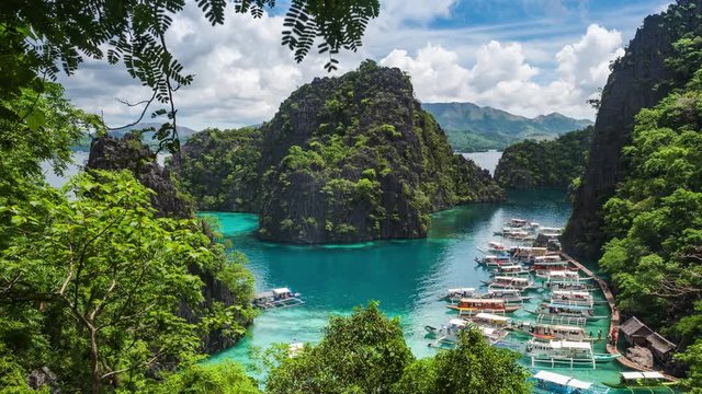 Coron island, Palawan, Philippines, time lapse view of Kayangan Lake viewpoint showing tourist outrigger boats and karst scenery.