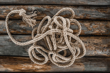 Obraz premium top view of nautical rope with knot on grunge wooden surface