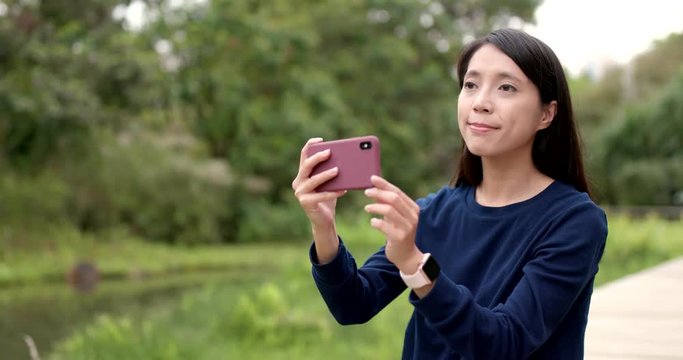 Woman using mobile phone for taking photo and video