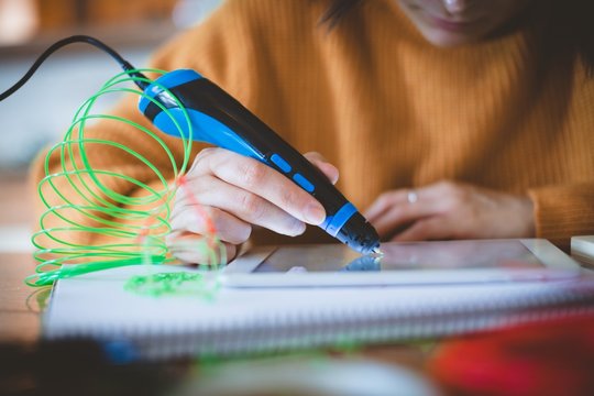 Woman using electric pen on digital tablet