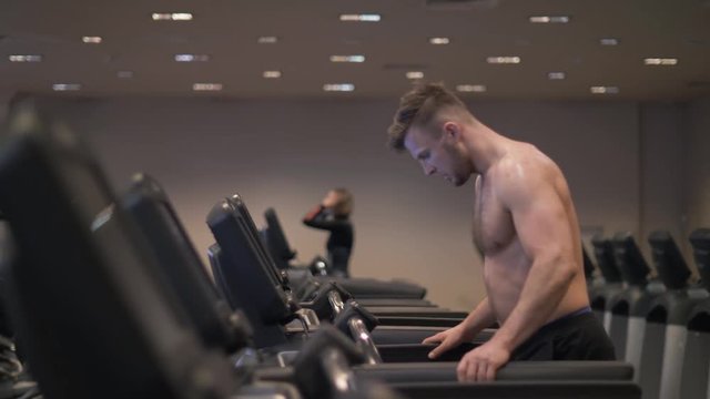 Man using screen treadmill for configuring program cardio exercise and running