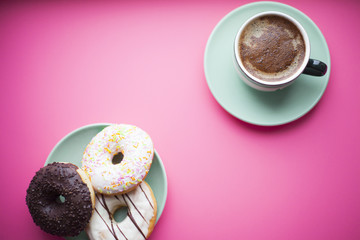 Freshly brewed cup of coffee with marshmallow, donuts and sweets on the pink background. Gifts with ribbon and hearts. Top view. Space for your text.