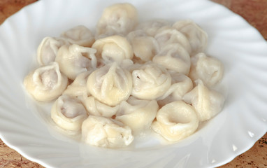 Dumplings on a plate on wooden table.