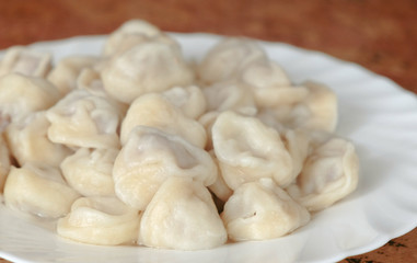 Dumplings on a plate on wooden table.