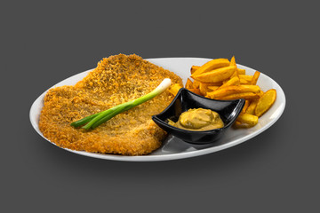 pork steak garnished with French fries, sauce and fresh green onion