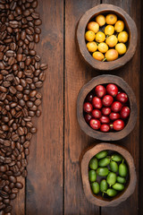 Coffee beans and fresh berries beans on wooden background