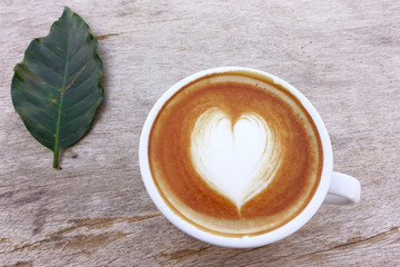 a cup of latte art coffee on wooden background
