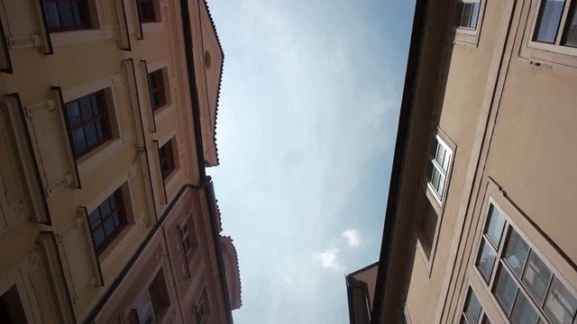 A walking shot down a old town Prague street looking up at the building facades and old cityscape,
