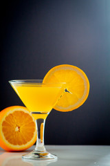Isolated drink. Glass of orange juice and slices of orange fruit isolated on dark background