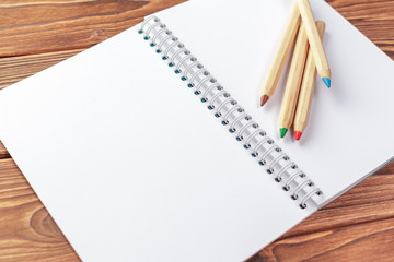 Office desk table top view. Notepad with blank pages on wooden table