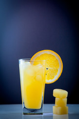 Isolated drink. Glass of orange juice and slices of orange fruit isolated on dark background