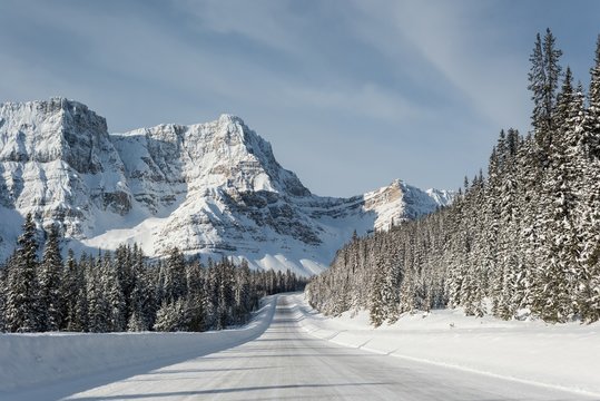 Snowy road through snow capped mountain