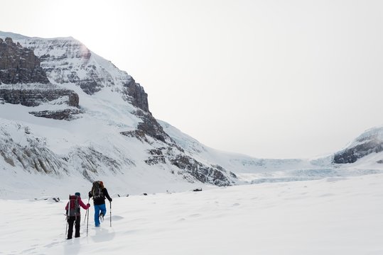 Couple walking on a snow capped mountain
