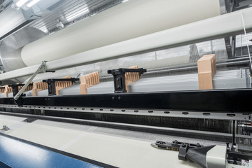 weaving loom at a textile factory, closeup. industrial fabric production line