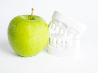The plaster bit bites against a green apple against a white background isolated