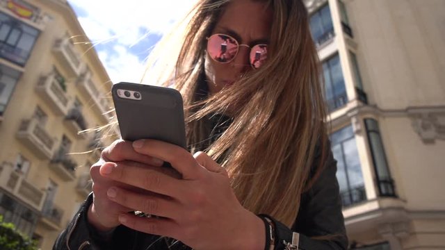 blond girl with smartphone in the street