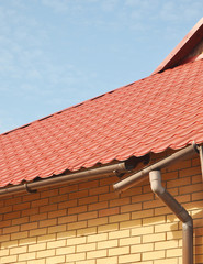 Naklejka premium Broken Rain Gutters. Ice dam. Closeup on new broken rain gutter system without roof protection. Icicles damage roof and gutter. Ice Damming.