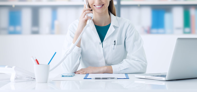 Smiling doctor on the phone