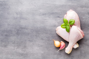 Chicken legs, fresh spice on a gray background.Top view.
