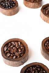 Close up of coffee beans in wooden bowl isolated on white background