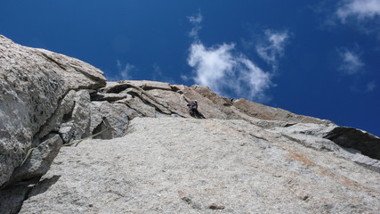 male rock climber on a steep granite route in the mountains near Chamonix in the French Alps