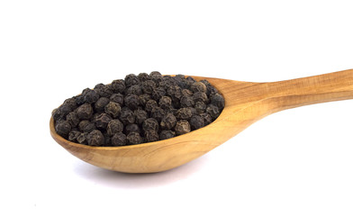Black pepper peas on a wooden spoon  on a white background