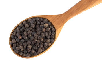 Black pepper peas on a wooden spoon  on a white background