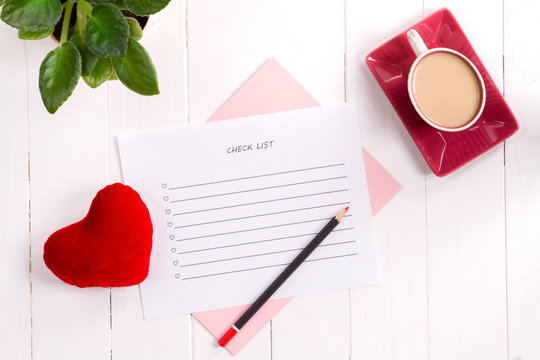 To do list in notepad with pencil and heart on wooden background