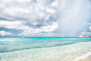 Sea with boats and port in grand turk, turks and caicos islands. Seascape with turquoise water on cloudy sky. Summer vacation on tropical island. Discovery, adventure and wanderlust