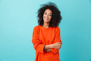 Colorful portrait of amazing woman in red shirt with afro hairstyle looking on camera with smile,...