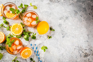 Cold summer drink. iced tea with lemon and mint, on grey stone background.  Copy space top view