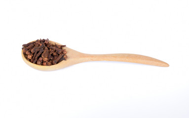 dry cloves in wooden spoon isolated on white background