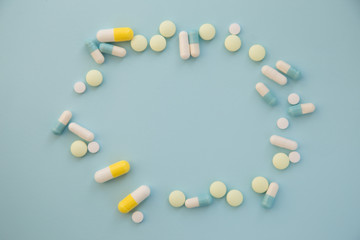  frame from multi colored pills and capsules on blue background.