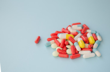 A lot of colorful medication and pills on a blue background.
