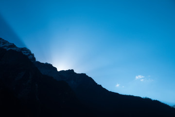 Sun beam behind mountain during morning time